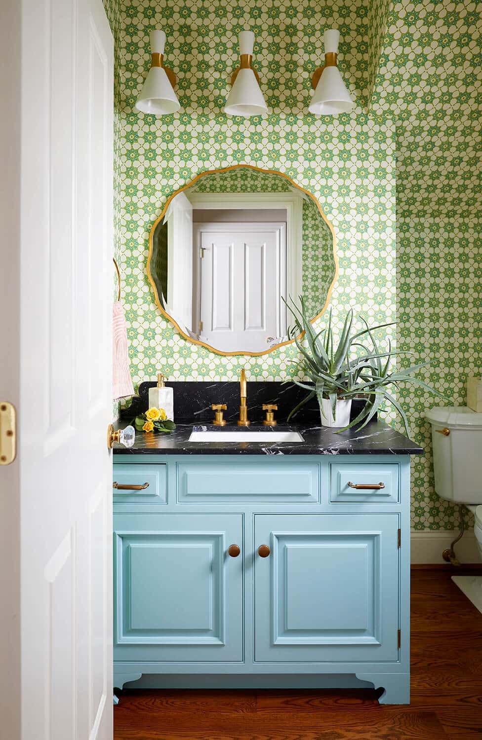 Reusch Interior Design's Founder and Lead Interior Designer, Laney Reusch, designed this colorful powder bathroom in Cincinnati's Walnut Hills neighborhood. The home was built in the 1920's. While still keeping the original character of the home, Reusch revitalized the space with a unique, green patterned wallpaper - that she had papered all the way up the powder room's sloped ceiling. The powder bath also features a fully-custom vanity in a light and vibrant blue, much like the color that Cincinnati Interior Designer Laney Reusch selected for her custom kitchen caibnets in her own home in Hyde Park. Walnut Hills Interior Design.